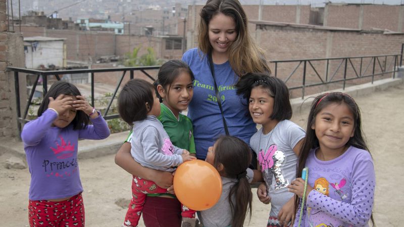 Rachel Canouse, Make a Miracle director of global relations and program development, surrounded by children from San Juan de Lurigancho, Lima, Peru. Courtesy of Brooklyn Etzel and Make a Miracle