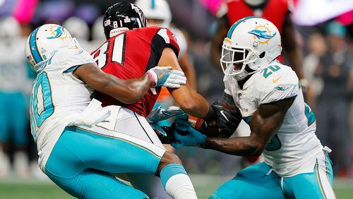 Cordrea Tankersley #30 defends as Reshad Jones #20 of the Miami Dolphins intercepts this pass intended for Austin Hooper #81 of the Atlanta Falcons at Mercedes-Benz Stadium on October 15, 2017 in Atlanta, Georgia. (Photo by Kevin C. Cox/Getty Images)