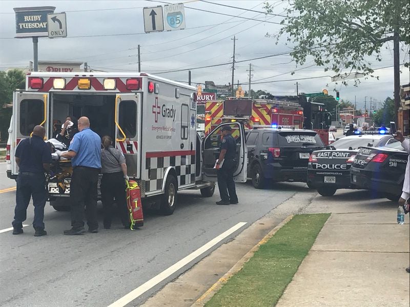 A woman was loaded into an ambulance after shots rang out in an East Point parking lot Wednesday afternoon. It's unclear whether she was shot.