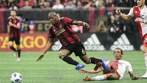 Atlanta United midfielder Darlington Nagbe (6) gets tripped up against the New England Revolution during the first half of an MLS soccer game, Saturday, Oct. 6, 2018. (John Amis)