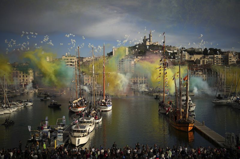 Fireworks go off as the Belem, the three-masted sailing ship which is carrying the Olympic flame, enters the Old Port in Marseille, southern France, Wednesday, May 8, 2024. The torch was lit in Greece last month before it was officially handed to France. The Paris 2024 Olympic Games will run from July 26 to Aug.11, 2024. (AP Photo/Daniel Cole)