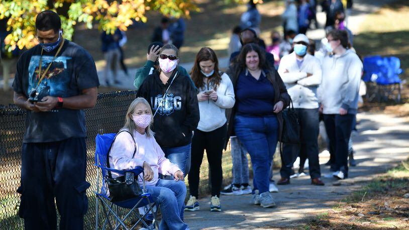 Deborah Wood, sitting on a camping chair, waits in lines to cast a ballot at the Shorty Howell Park Activity Building in Duluth, Georgia, on the last day of early voting on Oct. 30, 2020. (Hyosub Shin/Atlanta Journal-Constitution/TNS)