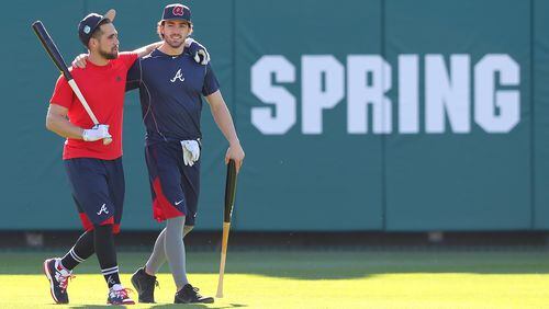 Braves infielder Dansby Swanson (right) walks arm-in-arm with outfielder Ender Inciarte after taking some batting practice at Champion Stadium Thursday Feb. 16, 2017, in Lake Buena Vista, Fla.