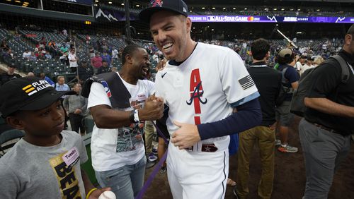 National League's Freddie Freeman, of the Atlanta Braves, laughs with former player Michael Bourn during batting practice prior to the MLB All-Star baseball game, Tuesday, July 13, 2021, in Denver. (AP Photo/David Zalubowski)