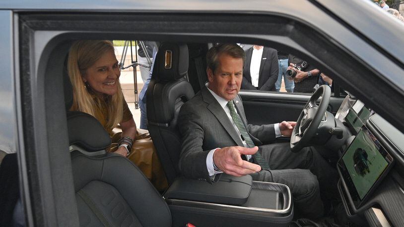 December 16, 2021 Atlanta - Georgia Governor Brian Kemp and First Lady Marty Kemp react as they sit inside Rivian R1T electric truck during a press conference at Liberty Plaza across from the Georgia State Capitol in Atlanta on Thursday, December 16, 2021. Electric vehicle maker Rivian on Thursday confirmed its plans to build a $5 billion assembly plant and battery factory in Georgia, which Gov. Brian Kemp called the largest single economic development project ever in this state's history. (Hyosub Shin / Hyosub.Shin@ajc.com)