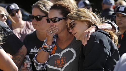 Jill Winter of San Diego (from left), Sue Heili of Foothill Ranch, Calif., and Kristy Hayhurst of Chino, Calif., gather with others at a makeshift memorial for victims of the mass shooting at the Borderline bar in Thousand Oaks, Calif., on Nov. 11. All three of them are survivors of the Route 91 Harvest country music festival mass shooting in Las Vegas in 2017. MEL MELCON / LOS ANGELES TIMES / TNS