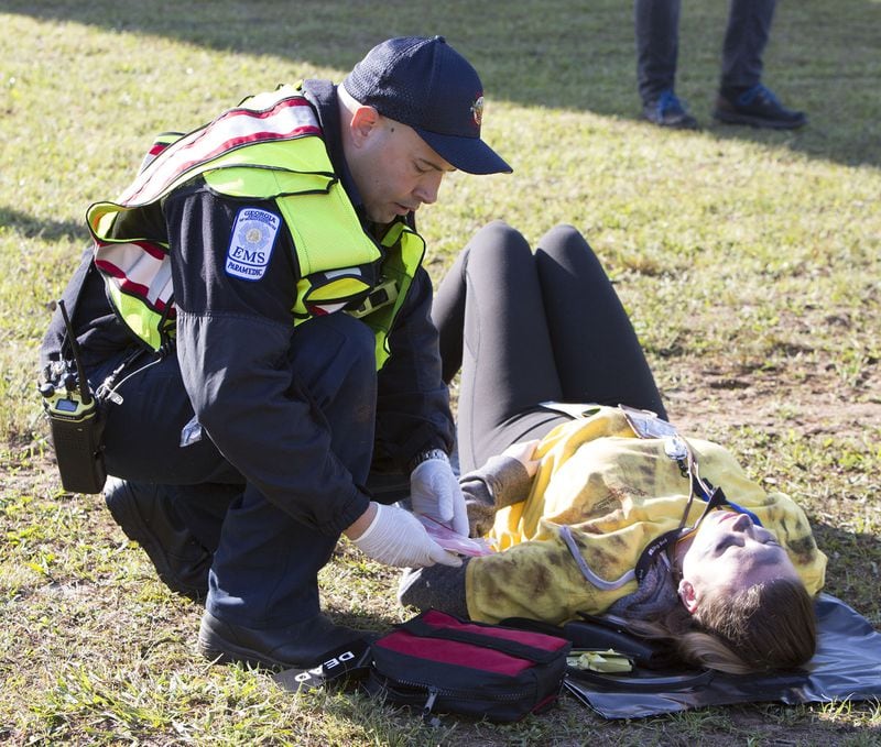 An EMS workers helped a victim as Hartsfield-Jackson International Airport held a full-scale disaster drill with Atlanta Firefighters, law enforcement, rescue personnel and nearly 150 volunteers who participated in a triennial exercise known as âBig Birdâ on Thursday, April 12, 2018. Airport personnel mobilized to a mock aircraft crash, extinguished the fire then triaged & treated the victims at a training site. The Federal Aviation Administration requires airports to conduct annual emergency preparedness drills and at least one full-scale drill every three years. (Photo by Phil Skinner)NOTE: getting Ids was impossible because the media was too far away.