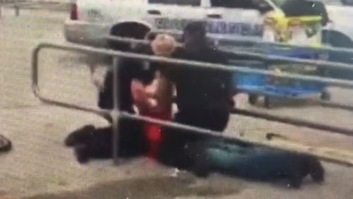 Video shot in a Riverdale Wal-Mart parking lot shows officers punching Derrick Barber on Wednesday. (Credit: Channel 2 Action News)