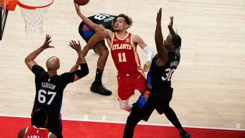 Atlanta Hawks' Trae Young (11) shoots against New York Knicks' Julius Randle (30) and Taj Gibson (67) during the first half in Game 3 of an NBA basketball first-round playoff series Friday, May 28, 2021, in Atlanta. (AP Photo/Brynn Anderson)