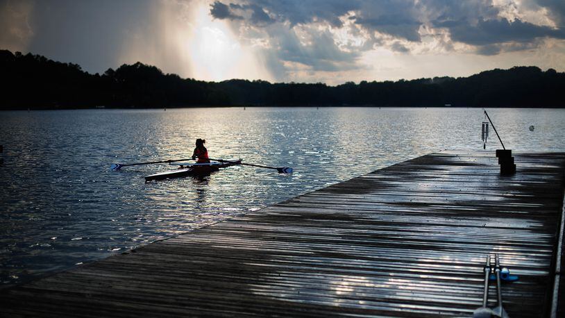 In this July 19, 2016, photo, a rower moves past the launching docks at Lake Lanier Olympic Park, home of the 1996 Summer Olympic Games rowing events, in Gainesville, Ga. This man-made lake still has its rowing facilities, which have been used for major competitions over the last two decades. This year, it hosted an Olympic qualifier for Rio and will host the Dragon Boat World Championships in 2018. (AP Photo/David Goldman)