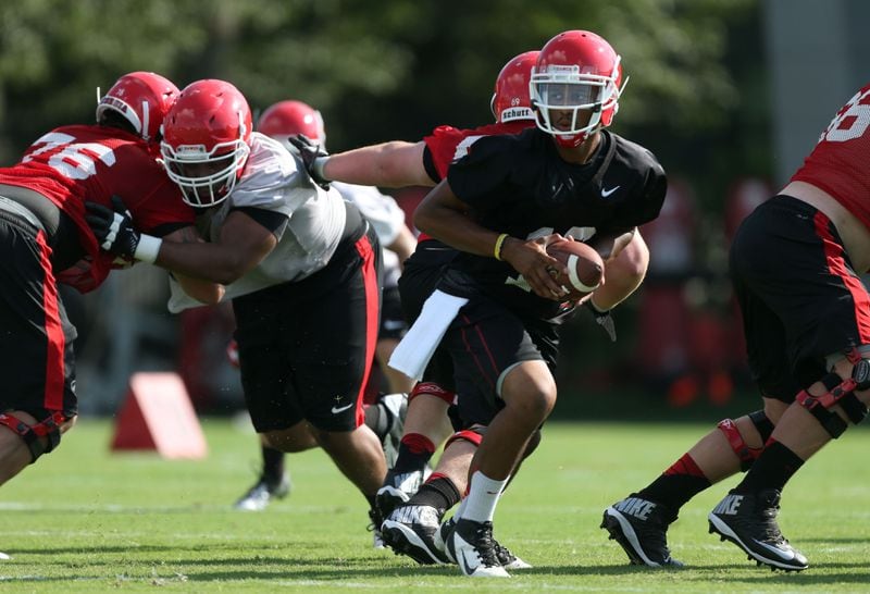 University of Georgia quarterback Christian LeMay (16) looks to hand the ball off to a tailback during the first day of practice at the University of Georgia Thursday afternoon in Athens, Ga., August 1, 2013. JASON GETZ / JGETZ@AJC.COM