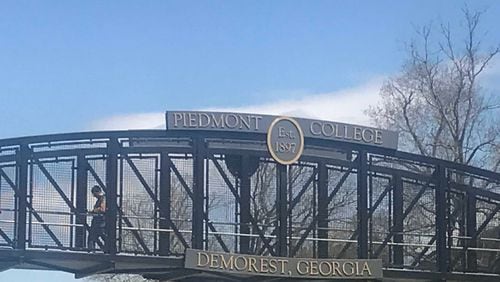 A man walks across the bridge connecting portions of Piedmont College’s main campus in Habersham County. ERIC STIRGUS / ESTIRGUS@AJC.COM