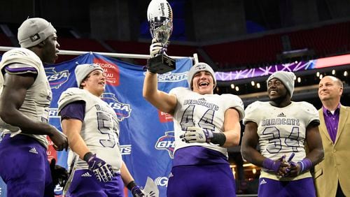 Bainbridge's Bowen Dodson lifts the trophy as from left, Roman Harrison, Jacob McLaughlin, and Randy Fillingame look on after their class 5A high school championship football game against Warner Robins, Tuesday, Dec., 11, 2018, at Mercedes-Benz Stadium, in Atlanta. Bainbridge won 47-41. (john Amis/Special)