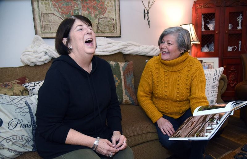 Toni Appling (left) shares a laugh with her friend Mary Schrepfer as they look at a dog coffee-table book together at Appling’s home in Johns Creek on Jan. 2, 2020. Appling, who has saved hundreds of dogs as a dog rescuer and co-founder of the Atlanta Dog Squad, is facing kidney failure, and friends such as Schrepfer are helping however they can. HYOSUB SHIN / HYOSUB.SHIN@AJC.COM