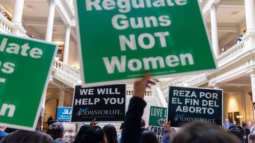 Supporters and opponents of abortion rights hold signs during a February rally at the Georgia Capitol in Atlanta. (Arvin Temkar / arvin.temkar@ajc.com)