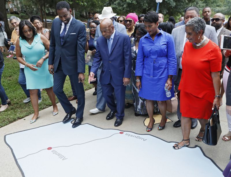 U.S. Rep. John Lewis, along with council member Andre Dickens, who introduced the ordinance to honor Lewis and Mayor Keisha Lance Bottoms, stop to look at one of the states painted on the John Lewis Ride to Freedom Play Space on the way to the sign unveiling.   