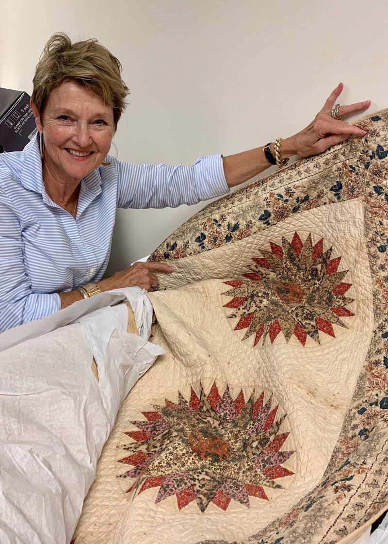 Marilyn Hubbard, Carrollton’s Southeastern Quilt & Textile Museum board president, shows off a Mariner' s Compass quilt from 1834. Howard Pousner/For The AJC