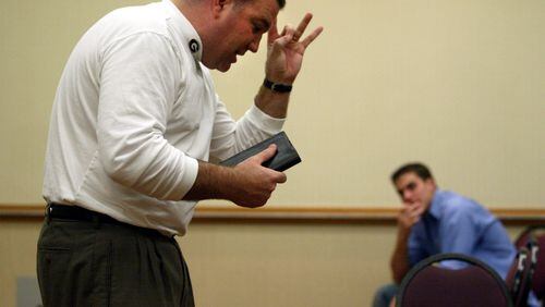 UGA team chaplain Kevin Hynes preaches to players, coaches and support staff during a 2002 church service held in a meeting room at the team hotel in New Orleans. Players were not required to attend. AJC file