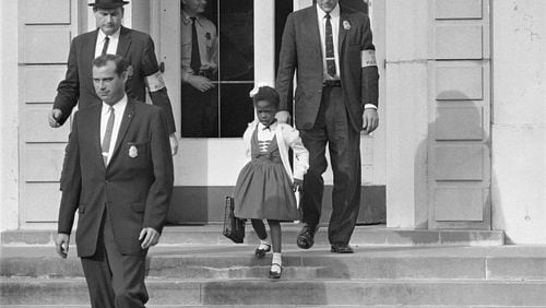U.S. Deputy Marshals escort 6-year-old Ruby Bridges from William Frantz Elementary School in New Orleans, in this November 1960. In 2014 a statue in her likeness was unveiled on the campus. (AP Photo/File)