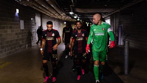 Atlanta United goalkeeper Brad Guzan #1, midfielder Jake Mulraney #23, and midfielder Mo Adams #29 walk out onto the pitch before the match against Chicago Fire FC at Soldier Field in Chicago, Illinois on Saturday July 3, 2021. (Photo by Jacob Gonzalez/Atlanta United)