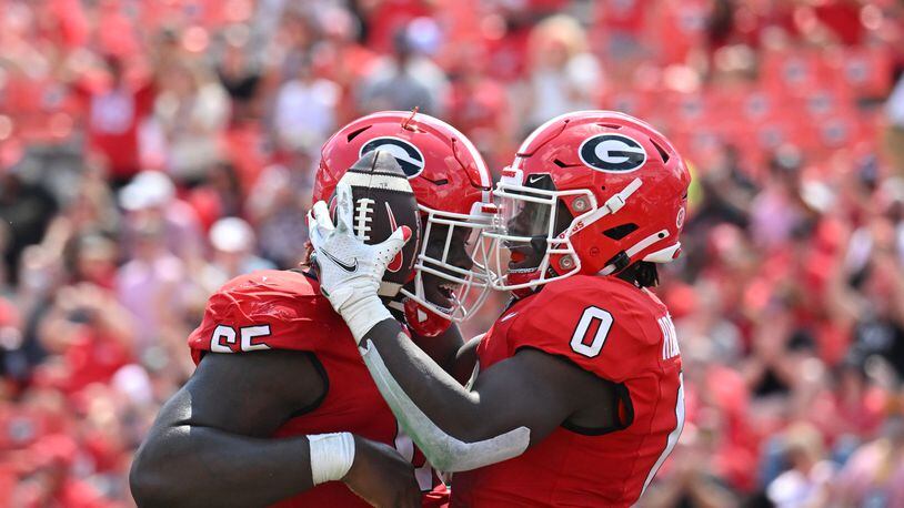 Georgia's running back Roderick Robinson II (0) celebrates with Georgia's offensive lineman Amarius Mims (65) after scoring a touchdown during the second half in an NCAA football game at Sanford Stadium, Saturday, September 9, 2023, in Athens. (Hyosub Shin / Hyosub.Shin@ajc.com)