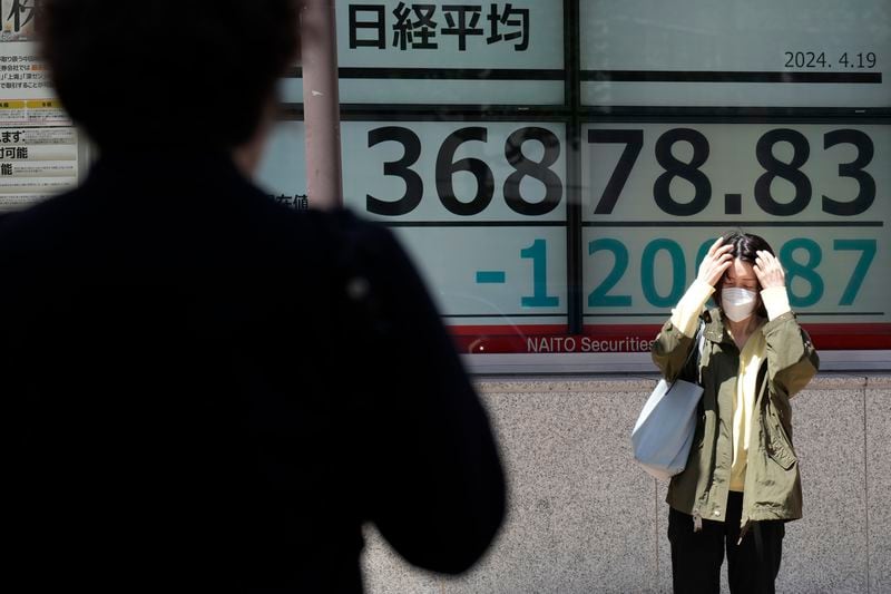 A person stands in front of an electronic stock board showing Japan's Nikkei 225 index at a securities firm Friday, April 19, 2024, in Tokyo. (AP Photo/Eugene Hoshiko)