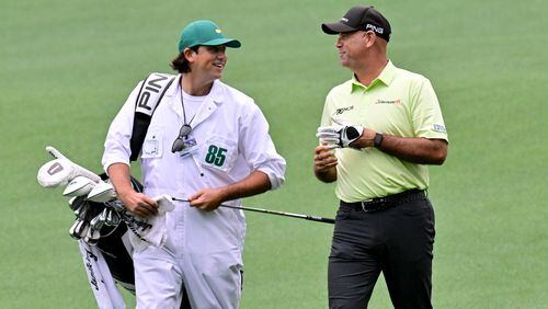 Stewart Cink talks with his caddie and son Reagan Cink after his second shot on the second fairway during the first round of the Masters on Thursday at Augusta National Golf Club. (Hyosub Shin / Hyosub.Shin@ajc.com)