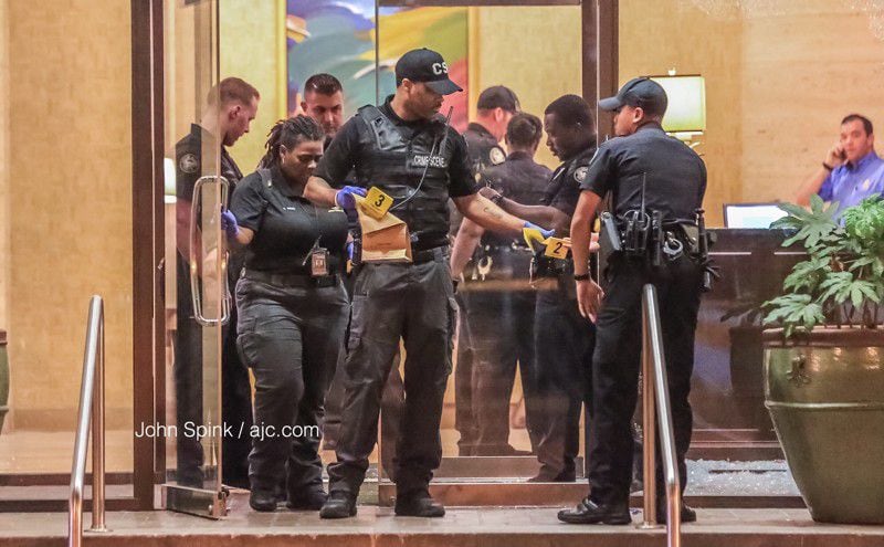Atlanta police crime scene and uniformed officers exit Peachtree Towers, where a man was shot early Wednesday in an attempted robbery. JOHN SPINK / JSPINK@AJC.COM