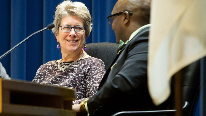 New DeKalb County Presiding Officer Kathie Gannon, left, talks with Greg Adams during the DeKalb County Board of Commissioners meeting Tuesday. STEVE SCHAEFER / SPECIAL TO THE AJC
