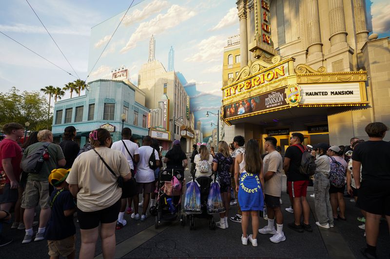FILE - Park guests stand outside the world premiere of Disney's "Haunted Mansion," July 15, 2023, at Disneyland in Anaheim, Calif. (AP Photo/Ashley Landis, File)