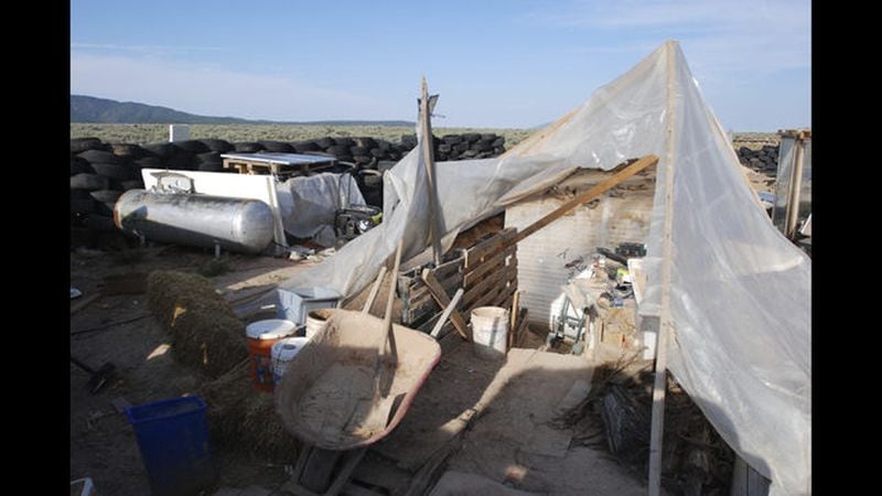  Various items litter a squalid makeshift living compound in Amalia, N.M., on Friday, Aug. 10, 2018, where five adults were arrested on child abuse charges and remains of a boy were found.  (AP Photo/Morgan Lee) </p>