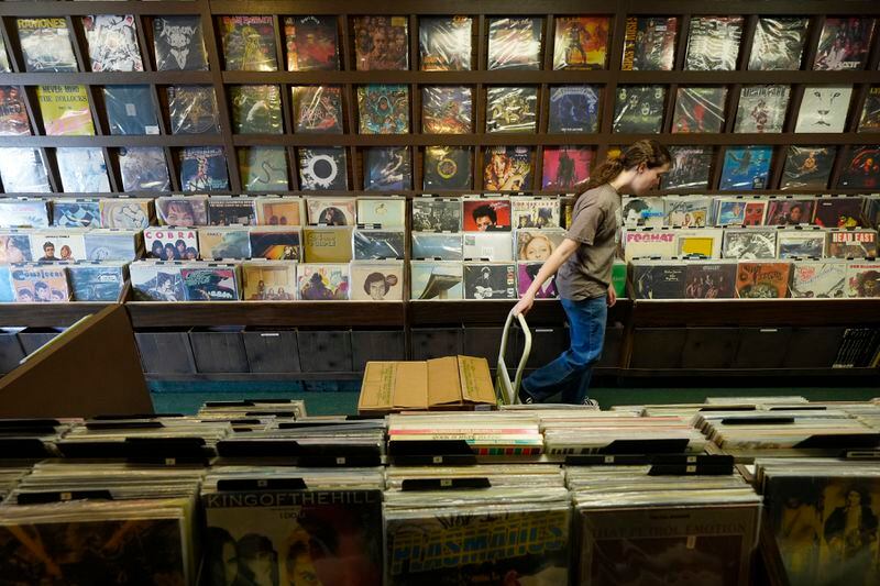 A store clerk at Tracks In Wax record shop hauls in the daily shipment of vinyl records, Thursday, April 18, 2024, in Phoenix. Special LP releases, live performances and at least one giant block party are scheduled around the U.S. Saturday as hundreds of shops celebrate Record Store Day amid a surge of interest in vinyl and the day after the release of Taylor Swift's latest album. (AP Photo/Ross D. Franklin)