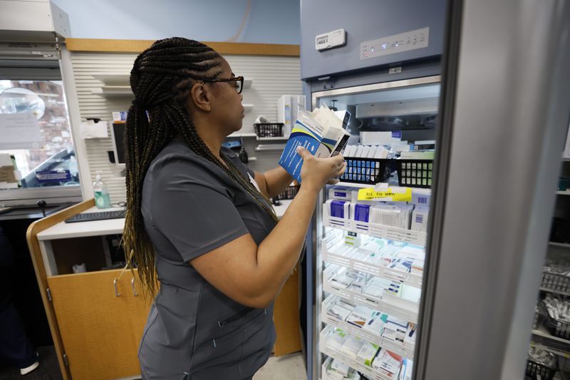 Pharmacist Estrella Clemons at CVS pulls vaccines from a fridge ready to be administrated to a person at the North Decatur Store earlier this month.
Miguel Martinez /miguel.martinezjimenez@ajc.com