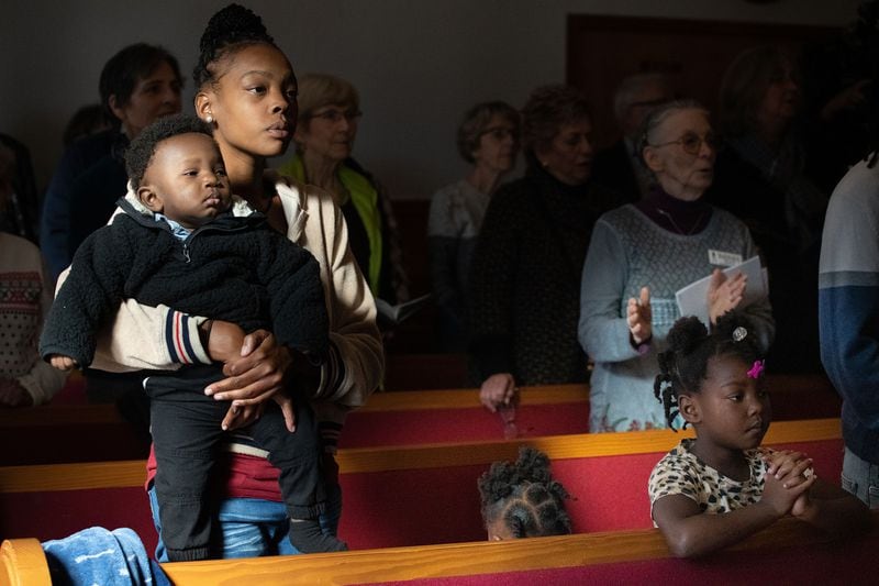 From left, Bria Thompson holds her almost 1-year-old son Princeton Thompson while her daughters Kaliyah Thompson, 2, and Samyah Thompson, 5, listen to the sermon at Bethel African Methodist Episcopal Church.