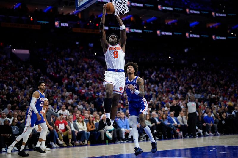 New York Knicks' OG Anunoby (8) goes up for a dunk past Philadelphia 76ers' Kelly Oubre Jr. (9) during the first half of Game 3 in an NBA basketball first-round playoff series, Thursday, April 25, 2024, in Philadelphia. (AP Photo/Matt Slocum)