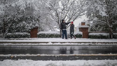 People walk along Shiloh Road in Kennesaw after a snowstorm hit metro Atlanta and North Georgia.