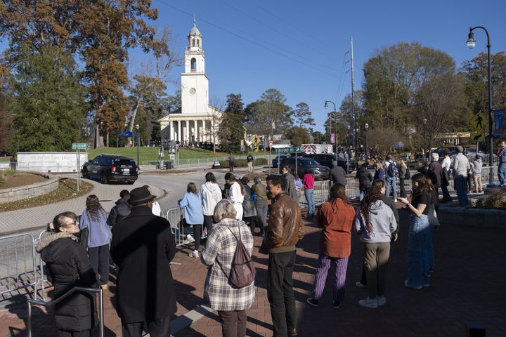 People on the edge of the Emory campus wait for the motorcade to pass by following the memorial service for former First Lady Rosalynn Carter in Atlanta on Tuesday, Nov. 28, 2023.   (Ben Gray / Ben@BenGray.com)