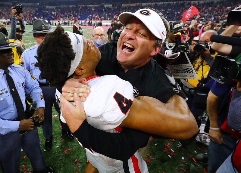 011022 Indianapolis: Georgia head coach Kirby Smart celebrates winning the College Football Playoff Championship game against Alabama getting a hoist from outside linebacker Bolan Smith on Monday, Jan. 10, 2022, in Indianapolis.  “Curtis Compton / Curtis.Compton@ajc.com”`