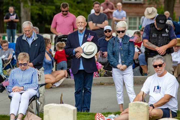 During a moment of silence for the soldiers lost since last Memorial Day, Army Aviation veteran Mark Maloney center, left, hat in hand, and his sister Mary Chappell, right, jean jacket, participate in the 77th annual Memorial Day Observance at the Marietta National Cemetery on Monday, May 29, 2003.  (Jenni Girtman for The Atlanta Journal-Constitution)