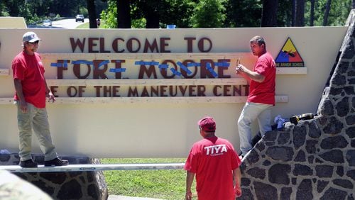 Workers change the sign at Fort Benning to the new name, Fort Moore, ahead of ceremonies on May 11, 2023 that will make the name change official. (Mike Haskey/Ledger-Enquirer)