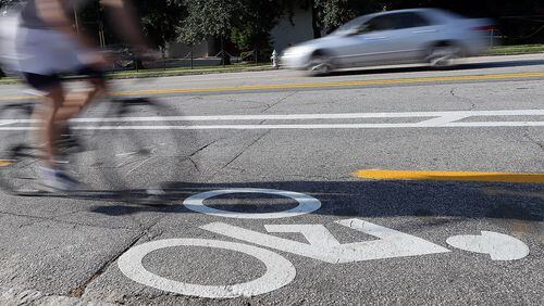 A cyclist makes his way up Tenth Street using the new cycle track that was recently added to the section of street between Monroe Drive and Charles Allen Drive along side Piedmont Park.