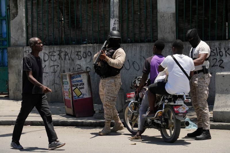 Police check motorists near the National Palace amid the sound of gunshots in the distance in Port-au-Prince, Haiti, Tuesday, April 30, 2024. (AP Photo/Ramon Espinosa)