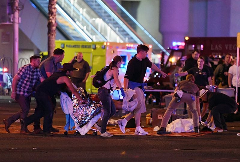 An injured person is tended to in the intersection of Tropicana Ave. and Las Vegas Boulevard after a mass shooting at a country music festival nearby on October 2, 2017 in Las Vegas, Nevada. A gunman opened fire on the music festival killing over 50 people. (Photo by Ethan Miller/Getty Images)