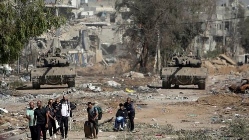 Palestinians flee from northern Gaza as Israeli tanks block the Salah al-Din road on Nov. 23 in central Gaza. (Mohammed Dahman/AP)