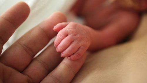A premature newborn holds onto an adult's fingers. (Jennifer Polixenni Brankin/Getty Images)