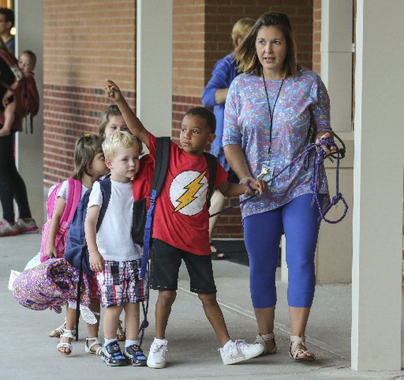 Emily Merritt brings her pre-schoolers into the building at Mountain View Elementary School in Cobb County. Cobb County schools started back to school Monday, July 31, 2017.