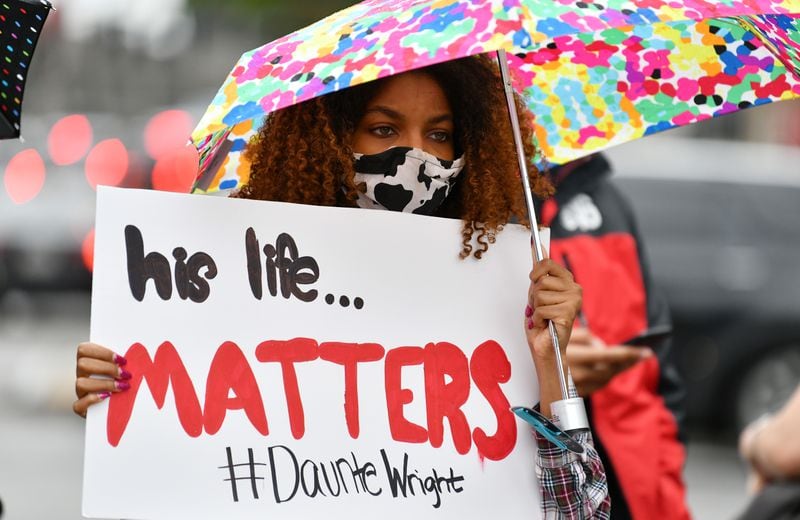 April 14, 2021 Atlanta - A protester holds a sign during a rally in solidarity with Minnesota - Justice for Daunte Wright at Centennial Olympic Park in Atlanta on Wednesday, April 14, 2021.  (Hyosub Shin / Hyosub.Shin@ajc.com)