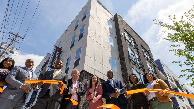 People cut a ribbon during the dedication for the new commercial and residential development at the King Memorial Station on Friday, May 19, 2022.  (Steve Schaefer / steve.schaefer@ajc.com)