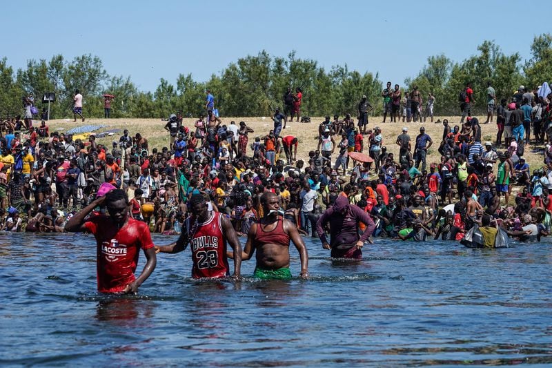 Haitian migrants, part of a group of more than 10,000 people staying in an encampment on the U.S. side of the border, cross the Rio Grande River to get food and water in Mexico, after another crossing point was closed near the Acuna Del Rio International Bridge in Del Rio, Texas on Sunday. (Paul Ratje/AFP/TNS)