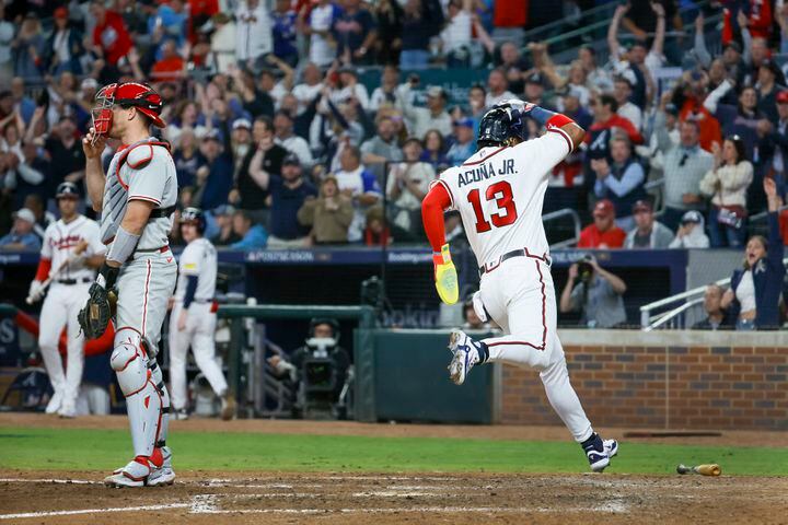 Atlanta Braves’ Ronald Acuna Jr. (13) scores past Philadelphia Phillies catcher J.T. Realmuto (10) on a single by Ozzie Albies during the sixth inning of NLDS Game 2 in Atlanta on Monday, Oct. 9, 2023.   (Miguel Martinez / Miguel.Martinezjimenez@ajc.com)